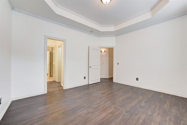 unfurnished bedroom featuring dark hardwood / wood-style floors, a raised ceiling, and crown molding