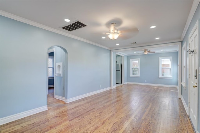 empty room with ceiling fan, light hardwood / wood-style floors, and ornamental molding