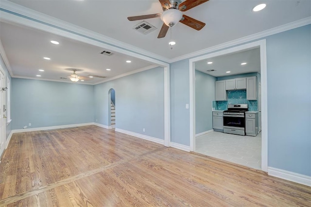 empty room featuring ceiling fan, light hardwood / wood-style floors, and crown molding