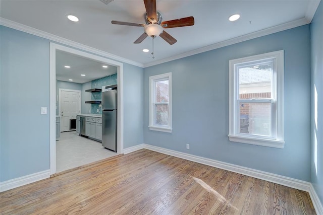 empty room with ceiling fan, light wood-type flooring, and ornamental molding