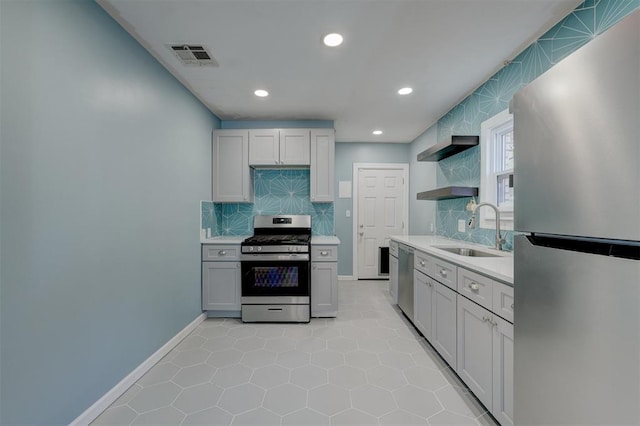 kitchen featuring appliances with stainless steel finishes, tasteful backsplash, light tile patterned floors, and sink