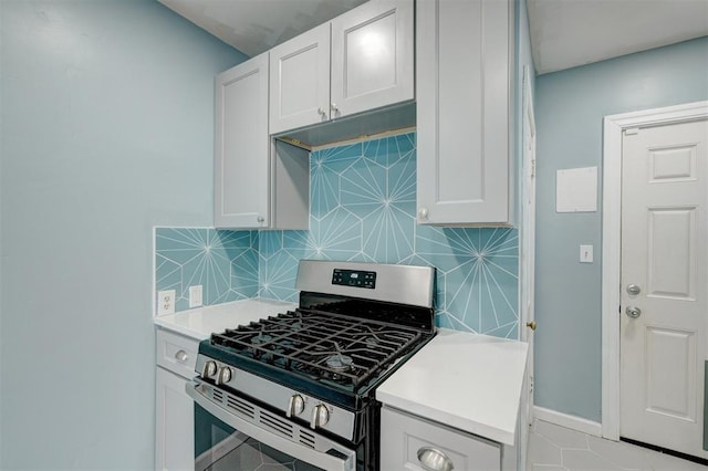 kitchen with white cabinets, tasteful backsplash, and stainless steel range with gas stovetop