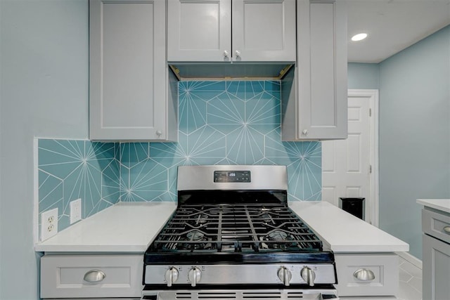 kitchen with gas stove and tasteful backsplash