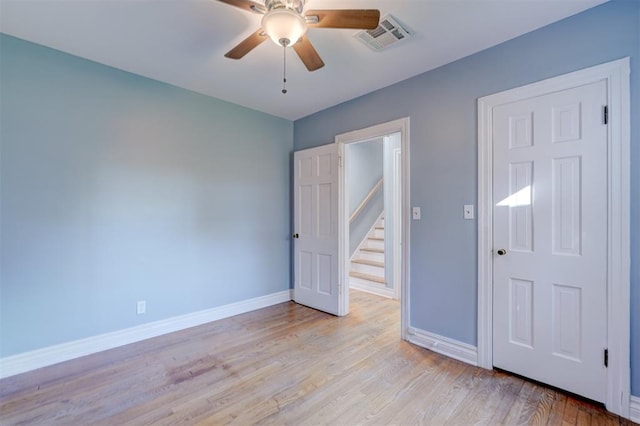 unfurnished bedroom with ceiling fan and light wood-type flooring