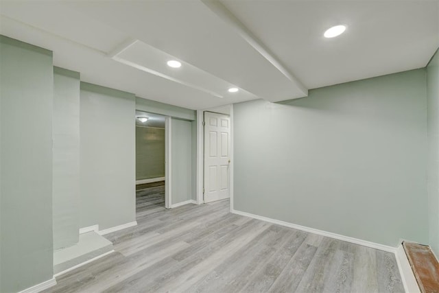 basement with light hardwood / wood-style flooring