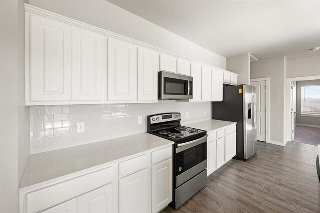 kitchen featuring backsplash, stainless steel appliances, white cabinetry, and dark hardwood / wood-style floors