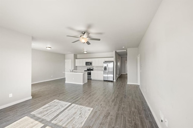 unfurnished living room with ceiling fan and dark wood-type flooring