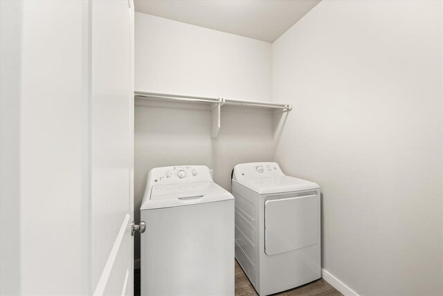 washroom with washer and clothes dryer and dark wood-type flooring