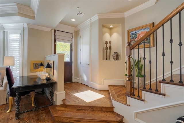 foyer entrance with hardwood / wood-style flooring and ornamental molding