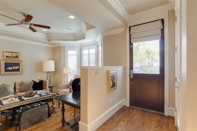 entryway with a tray ceiling, ceiling fan, hardwood / wood-style floors, and ornamental molding