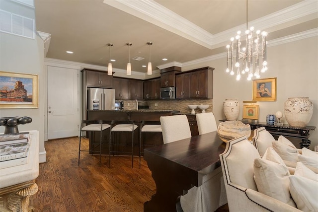 dining area featuring dark hardwood / wood-style floors, crown molding, and a chandelier