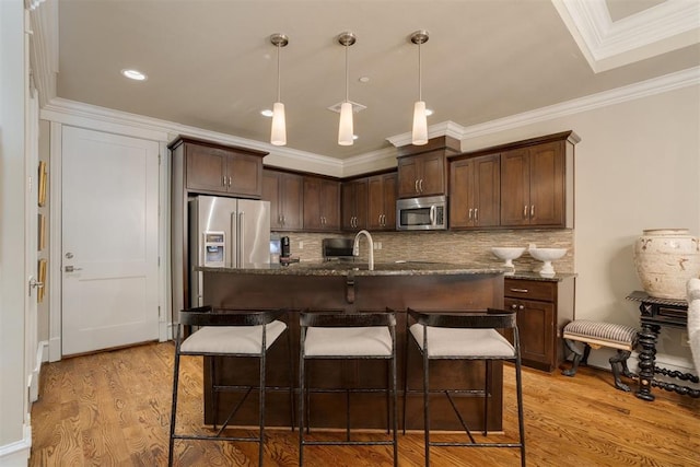 kitchen with dark brown cabinetry, stainless steel appliances, and light hardwood / wood-style floors