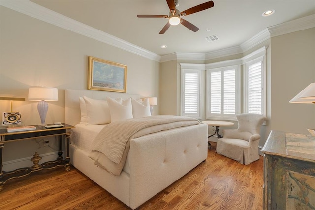 bedroom featuring ceiling fan, wood-type flooring, and ornamental molding