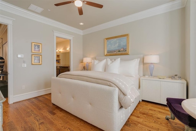 bedroom with ceiling fan, light wood-type flooring, ornamental molding, and ensuite bath