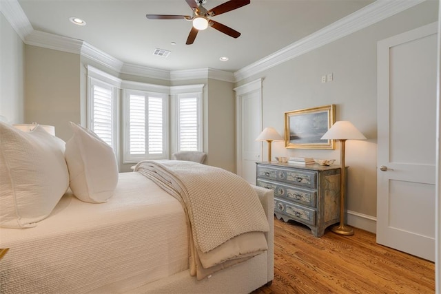 bedroom featuring ceiling fan, light wood-type flooring, and crown molding