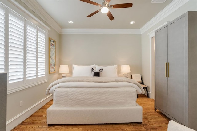 bedroom with ceiling fan, multiple windows, and light hardwood / wood-style flooring