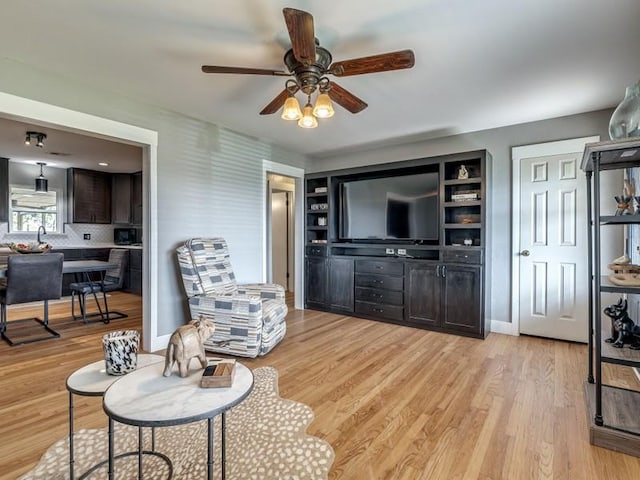 living room with ceiling fan and light wood-type flooring