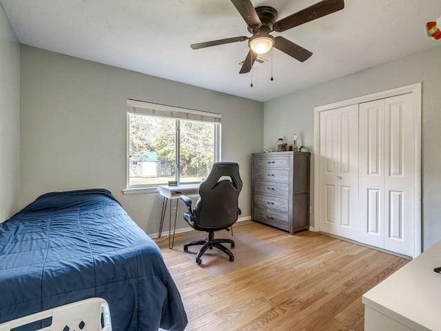 bedroom with a closet, light hardwood / wood-style floors, and ceiling fan