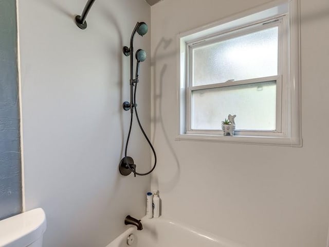 bathroom featuring washtub / shower combination and toilet