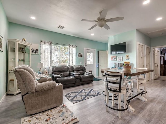 living room with ceiling fan and light hardwood / wood-style flooring