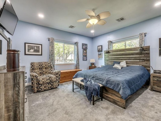 carpeted bedroom with multiple windows and ceiling fan