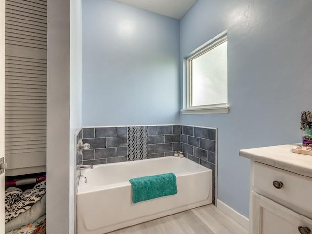 bathroom featuring vanity, a bathtub, and wood-type flooring