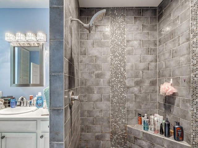 bathroom featuring a tile shower and vanity