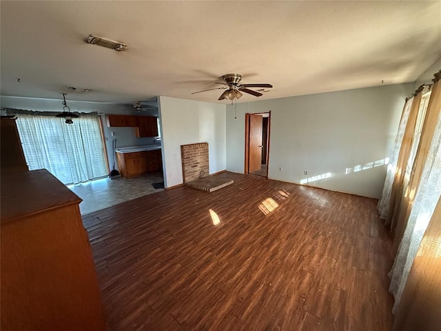 unfurnished living room with dark hardwood / wood-style flooring and ceiling fan