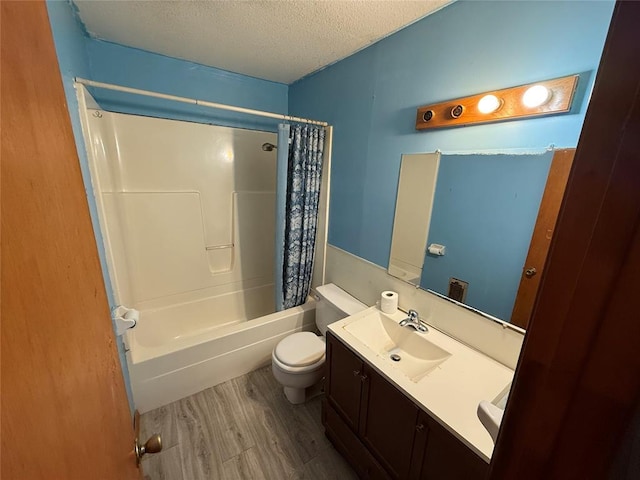 full bathroom with hardwood / wood-style floors, a textured ceiling, toilet, vanity, and shower / tub combo