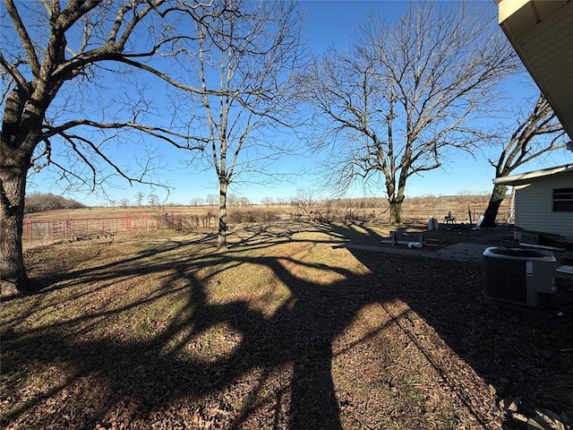 view of yard featuring a rural view and central AC unit