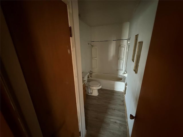 bathroom featuring washtub / shower combination, wood-type flooring, and toilet