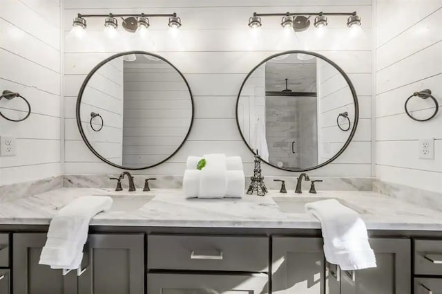 bathroom with vanity, an enclosed shower, and wooden walls