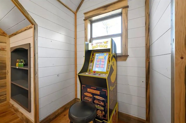 recreation room with wood walls, dark hardwood / wood-style flooring, and vaulted ceiling