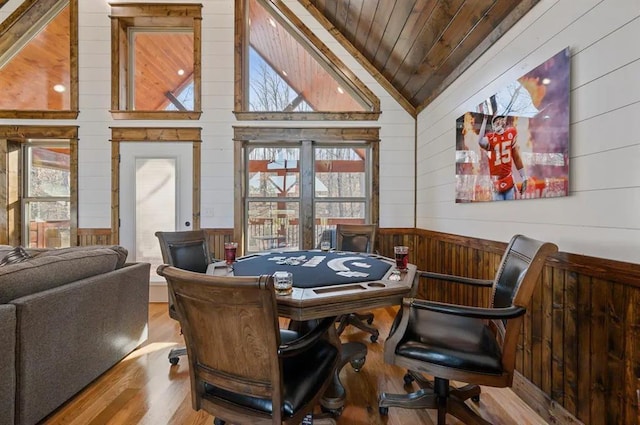 recreation room with light wood-type flooring, vaulted ceiling, wooden walls, and wood ceiling