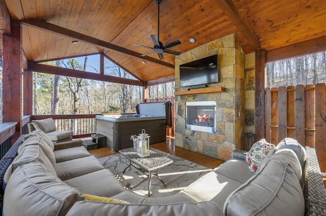 living room featuring wood ceiling, an outdoor stone fireplace, ceiling fan, lofted ceiling with beams, and hardwood / wood-style flooring