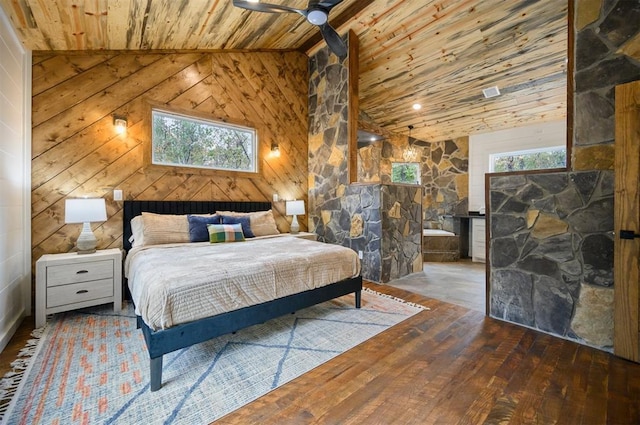 bedroom with multiple windows, wooden walls, wood ceiling, and hardwood / wood-style flooring