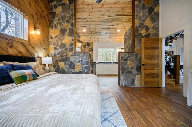 unfurnished bedroom with wood walls, dark hardwood / wood-style flooring, and high vaulted ceiling