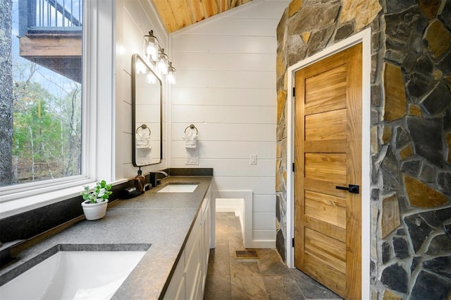 bathroom with wooden ceiling, a shower, lofted ceiling, wooden walls, and vanity