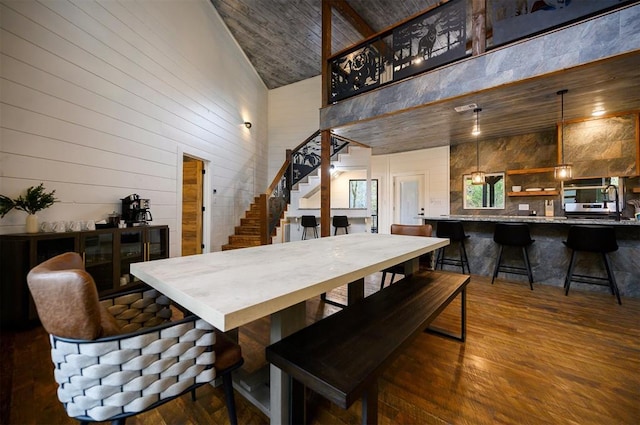 dining room featuring wooden walls, wood-type flooring, wood ceiling, and high vaulted ceiling