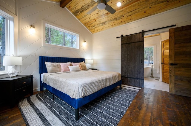 bedroom featuring a barn door, lofted ceiling with beams, and multiple windows