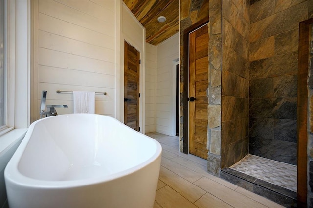 bathroom featuring separate shower and tub, wood walls, and wooden ceiling