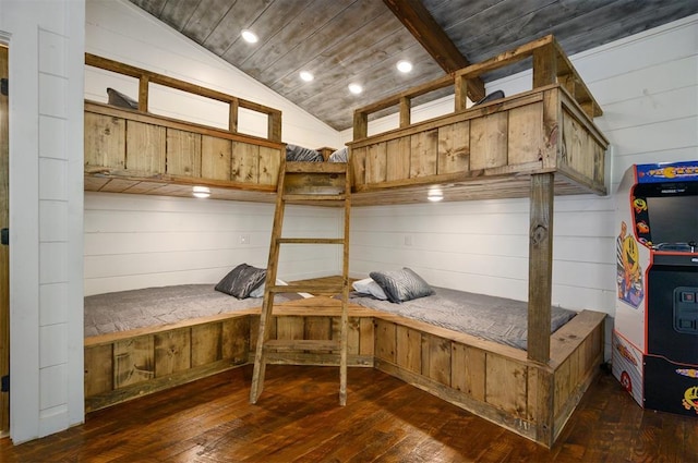 unfurnished bedroom with wooden walls, dark hardwood / wood-style flooring, wood ceiling, and vaulted ceiling