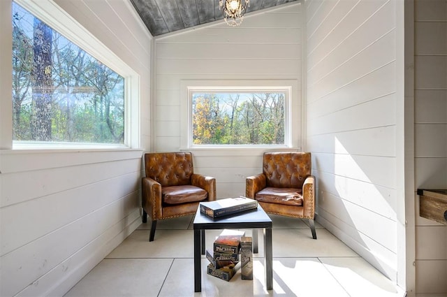 sitting room with wooden walls and lofted ceiling