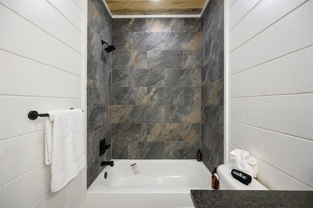 bathroom with wood walls and tiled shower / bath