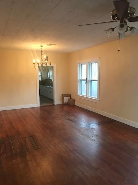 spare room featuring ceiling fan with notable chandelier and dark hardwood / wood-style flooring