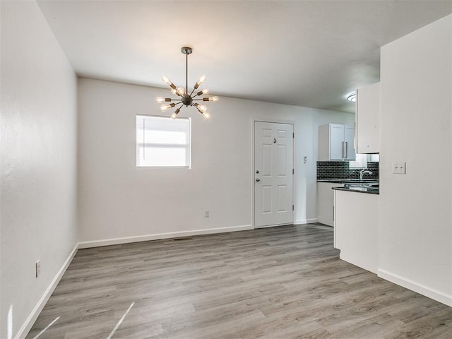 interior space with light hardwood / wood-style flooring and a notable chandelier