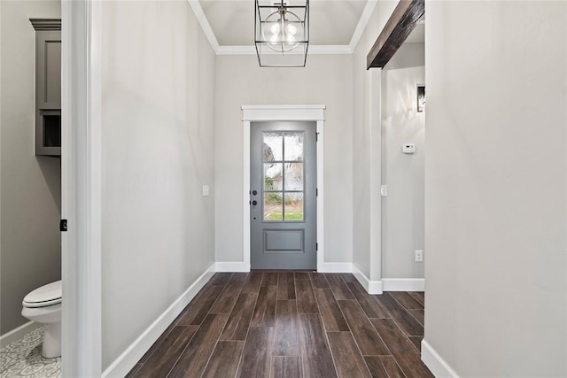 doorway to outside featuring a chandelier and ornamental molding