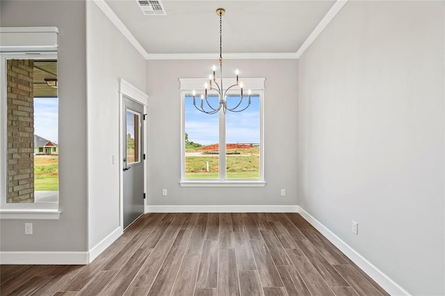 unfurnished dining area with ornamental molding, a notable chandelier, and hardwood / wood-style floors