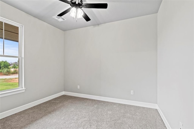 empty room featuring ceiling fan and carpet