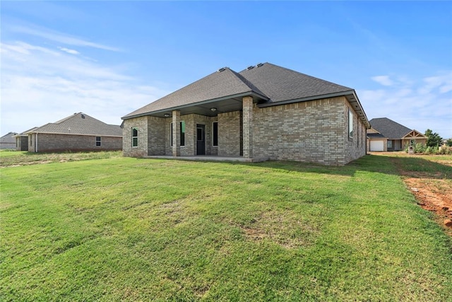 back of house with a lawn and a patio